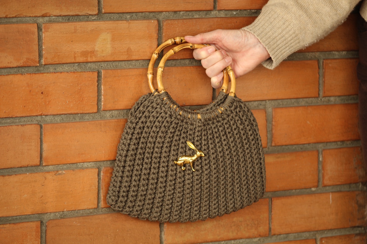 Cartera de crochet color oliva con asas de bambú y dije de liebre